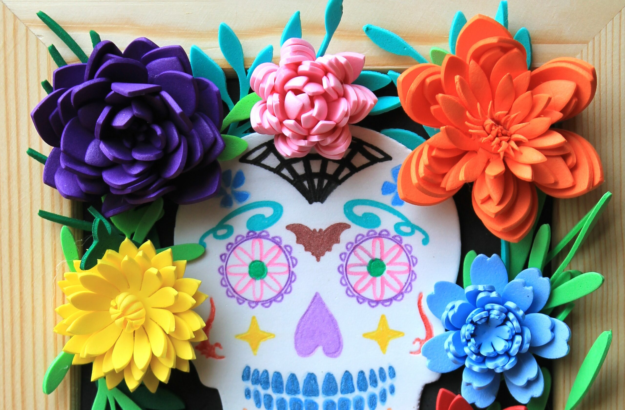 cadre fleurs en mousse qui entourent une calavera mexicaine colorée