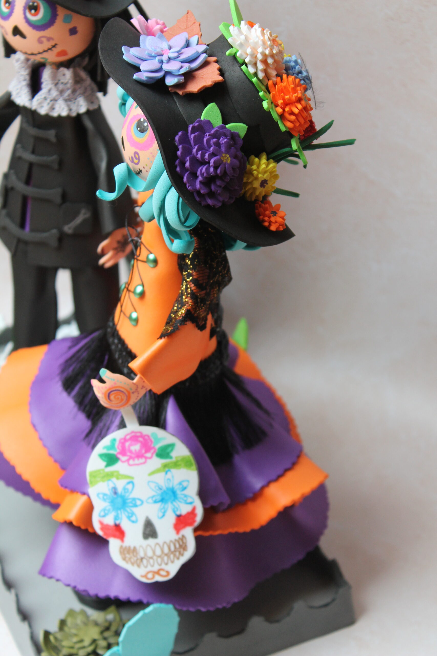 la catrina qui célèbre le dia de la muerte tient dans sa main une calavera ou sugar skull