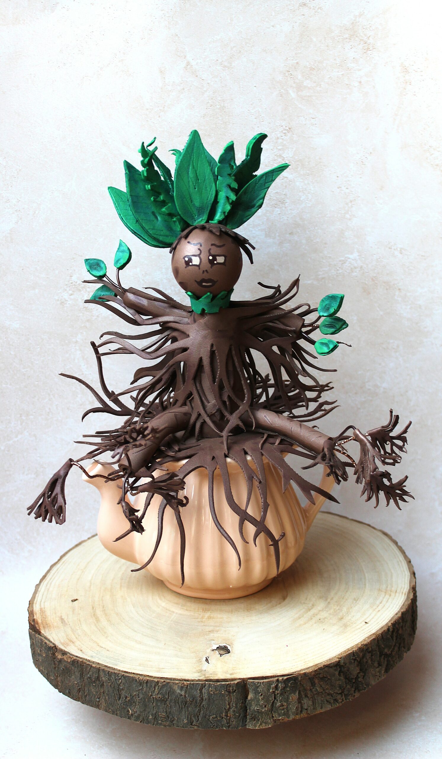 figurine mandragore artisanale assiste sur une théière